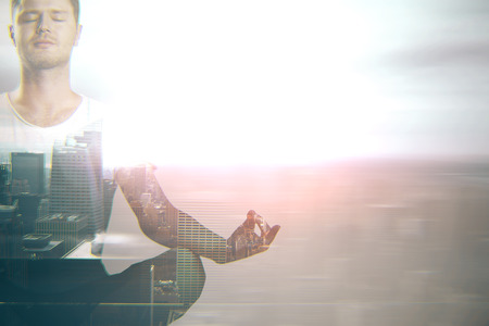 Meditating young man on city background with copy space. Double exposure