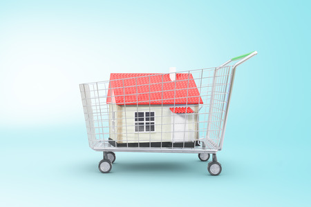 Trolley with red house on blue background. Concept of buying property. 3D Renderingの写真素材