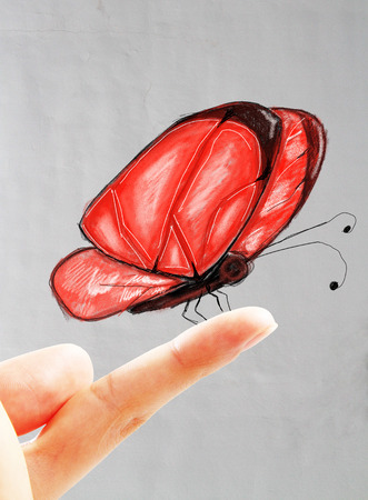 Beautiful red butterfly drawing sitting on male finger. Concrete wall backgroundの写真素材