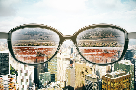 Close up of abstract eyeglasses with landscape view on city background. Vision concept. 3D Renderingの写真素材
