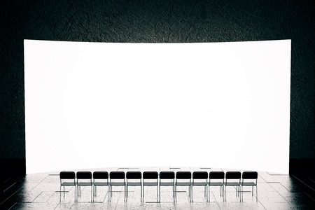 Front view of blank screen and row of seats  in dark interior with reflections on floor. Mock up, 3D Rendering. Presentation conceptの写真素材