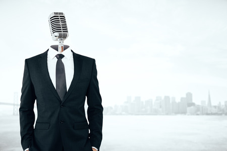 Mic headed businessman on city background with copy space.の写真素材