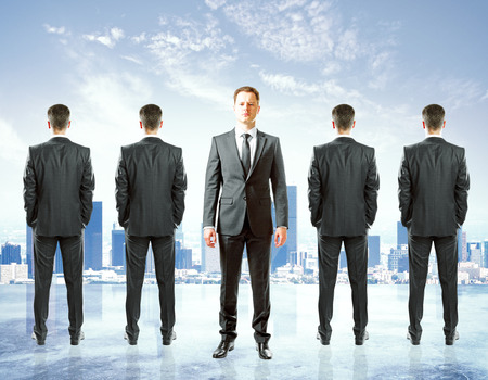 Row of businessmen with only once facing camera. City background.の写真素材
