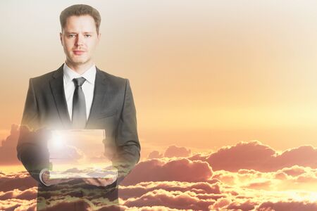 Man with book stack on sky background. Double exposure.の写真素材