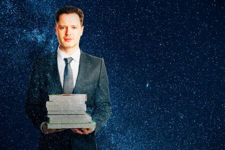 Man with book stack on space background. Double exposure.の写真素材