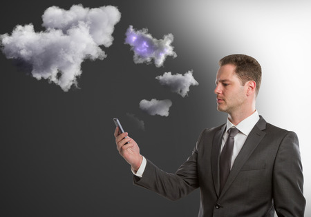 Handsome young man holding smartphone with abstract clouds. Cloud sync concept