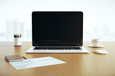 Close up of blank laptop placed on wooden desktop with coffee cup and supplies. Blurry city background. Mock up, 3D Renderingの写真素材