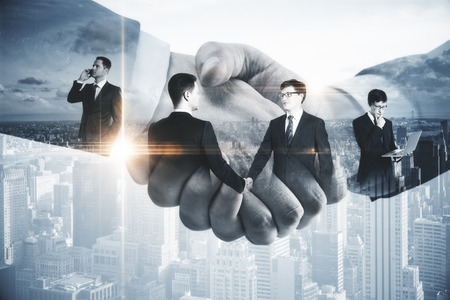 Handsome businessmen shaking hands on modern city background. Contract concept. Double exposureの写真素材