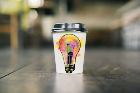 Close up of take away coffee cup with creative lamp sketch. Idea conceptの写真素材