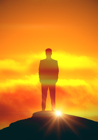 Back view of businessman silhouette on mountain top and sunrise background. Leadership conceptの写真素材