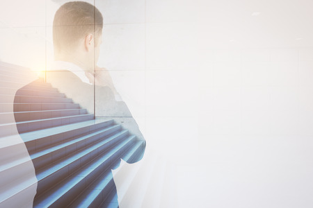 Back view of thoughtful male with stairs on city background. Success and growth concept. Double exposureの写真素材