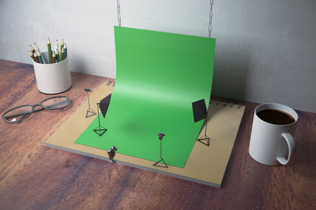 Creative tiny photo studio made out of supplies: green paper, coffee cup, pencils, glasses and other items on wooden background. 3D Renderingの写真素材