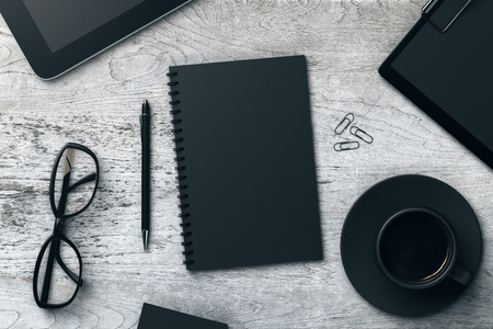 Top view of aged wooden office table with black notepad, coffee cup, pen, glasses, clips, tablets and other items. Workplace concept. Mock up, 3D Renderingの写真素材