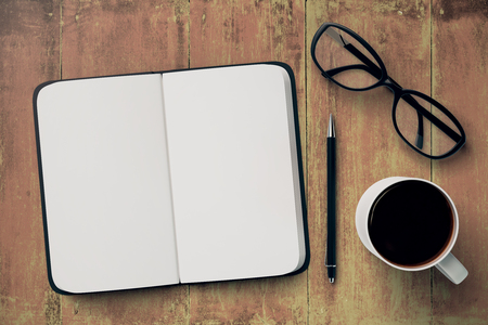 Top view of wooden desktop with open copybook, coffee mug, pen and glasses. Copy space for text. 3D Renderingの写真素材