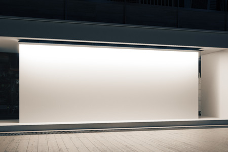 Empty glass shopfront with blank white banner at night. Retail  concept. Mock up, 3D Renderingの写真素材
