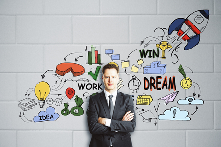 Confident young businessman on light backkground with launching rocket sketch. Entrepreneurship conceptの写真素材