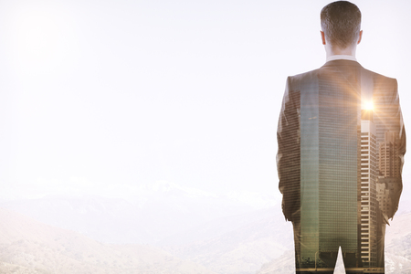 Back view of young businessman on abstract city background with copy space. Employment concept. Double exposureの写真素材