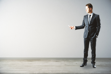 Businessman in interior drawing something on light wall. Mock up, 3D Renderingの写真素材