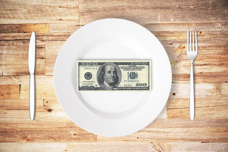 Top view of cutlery and plate with dollar bill on wooden table. Cash concept. 3D Renderingの写真素材