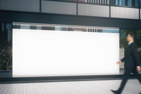 Businessman passing glass storefront with empty billboard. Commerce concept. Mock up, 3D Renderingの写真素材