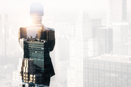 Back view of thoughtful young businessman on abstract city background with copy space. Search concept. Double exposureの写真素材