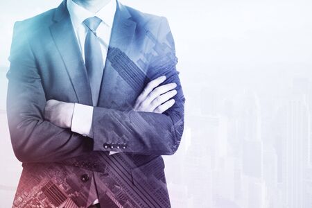 Businessman with folded arms on abstract city background with copy space. Research concept. Double exposureの写真素材