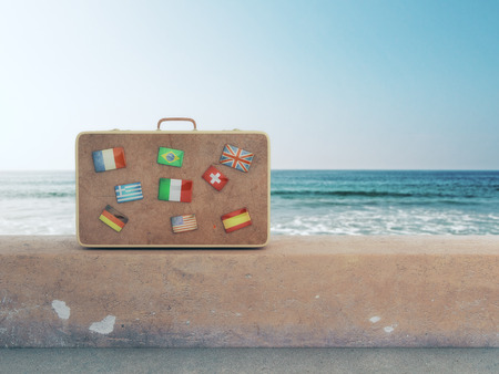 Suitcase with flags placed on concrete surface with sea and sky view. Travel concept. 3D Renderingのeditorial素材