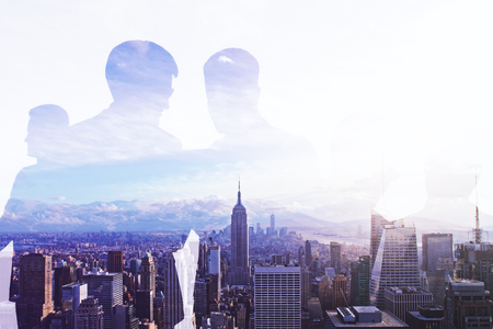 Businessmen silhouettes on creative white city and sky background. Conference concept. Double exposureの写真素材