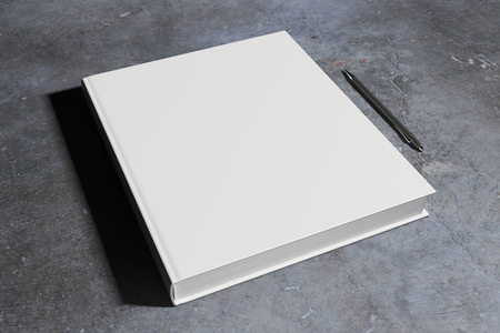 Blank white hardcover notepad and pen placed on concrete desk. Supplies, stationery items, paperwork concept. Mock up, 3D Renderingの写真素材