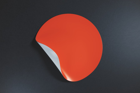 Red round sticker with curled peel off corner on dark background. Info concept. Mock up, 3D Renderingの写真素材