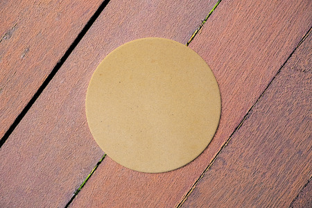 Close up of round cardboard tag on wooden desktop. Advertising concept. Mock up, 3D Rendering 