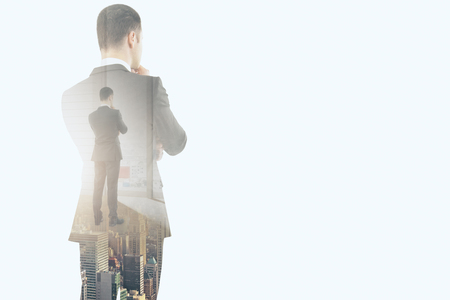 Unrecognizable businessman standing on abstract whte city background with copy space. Success and forward concept. Double exposure の写真素材