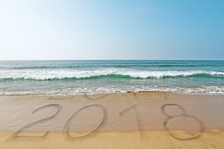 Beach backdrop with wave washing away year 2017 and revealing 2018. New Year conceptの写真素材
