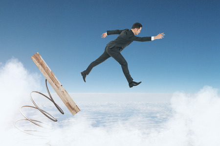 Abstract image of businessman on start up mechanism. Cloudy sky background. Entrepreneurship and forward concept の写真素材