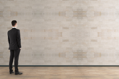 Side view of young businessman looking at empty wall in modern interior. Mock up, 3D Rendering の写真素材
