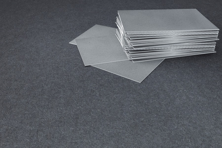 Close up of empty business/visiting cards on textured concrete background. Mock up, 3D Rendering 