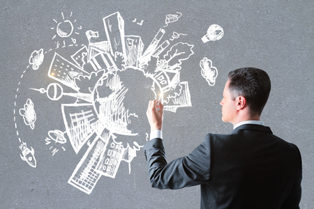 Side view of attractive white man drawing creative eco sketch on concrete wall background. Environment and pollution concept の写真素材