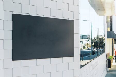 Close up of empty black poster on modern building with city reflections. Advertisement and commercial concept. Mock up, 3D Rendering の写真素材