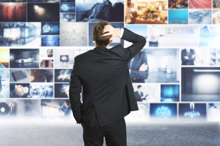 Businessman looking at abstract digital picture gallery. Multimedia and touchscreen conceptの写真素材
