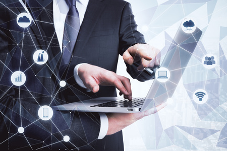 Side view and close up of businessmen hands using laptop with creative digital business hologram....