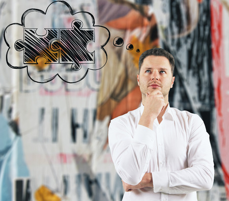 Handsome european businessman thinking about puzzle pieces on blurry background. Success and...