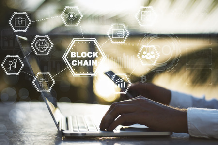 Blockchain technology concept with diagram of chain and encrypted block at businessman with smartphone typing on laptop background. 3D renderの写真素材