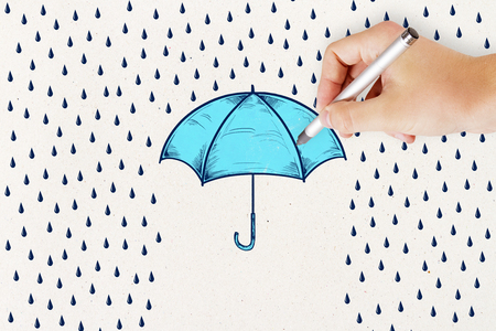 concept of protection and security wall with hand and pencil drawing rain and blue umbrella.の写真素材