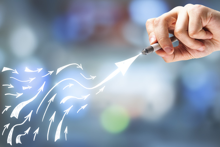 man hand drawing white arrows at abstract blured backgroundの写真素材