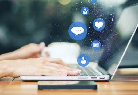 Hands using social media laptop with icons. Comunication and technology conceptの写真素材