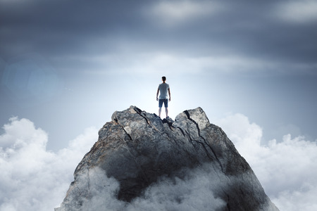 Businessman standing on abstract mountain on sky background. Promotion and leader conceptの写真素材