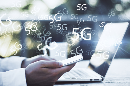 Side view of hands using laptop and smartphone with 5G internetの写真素材