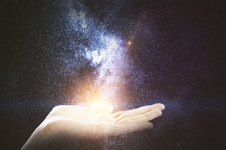 Female hand holding abstract space milky way. Fantasy concept. Double exposureの写真素材