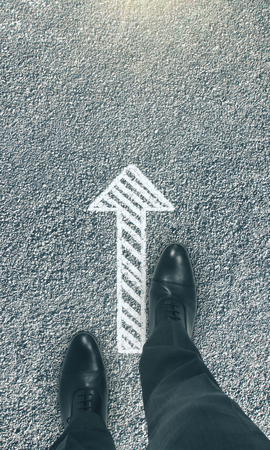 Top view of businessman feet with arrow on asphalt. Direction and choose conceptの写真素材