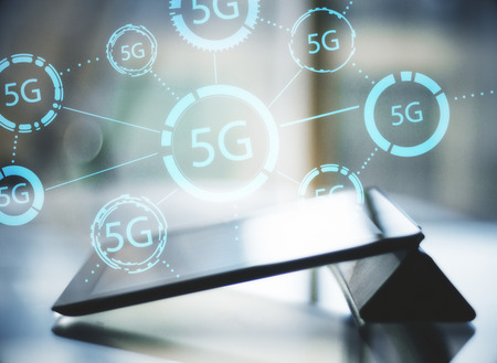 Close up of tablet with glowing 5G hologram. Web and speed concept. Double exposure